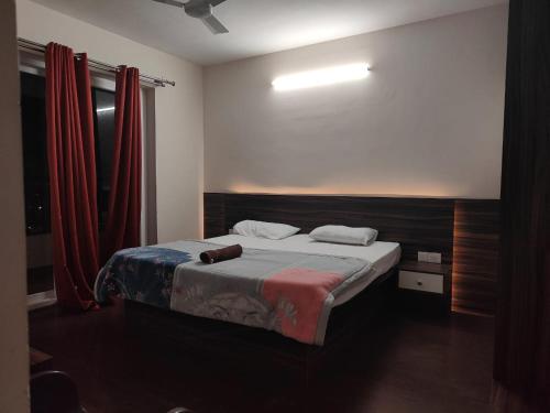 a bedroom with a bed with a red curtain at Modern 3BHK with fully equipped kitchen on 15Floor only for families in Bengaluru