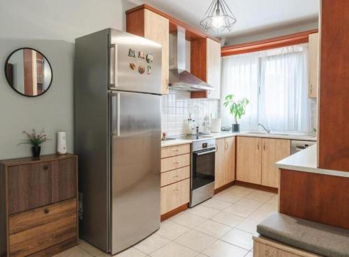 a kitchen with a stainless steel refrigerator and wooden cabinets at Rea Apartment in Argostoli