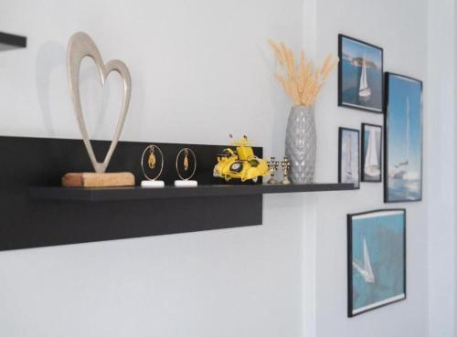 a black shelf on a wall with framed pictures at Rea Apartment in Argostoli