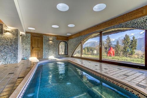 - une piscine intérieure dans une maison dotée d'une grande fenêtre dans l'établissement Chalet 1937, à Passy