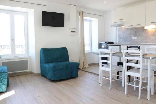 - un salon avec une table et une chaise bleue dans l'établissement Appt Studio LA ROCHELLE - LR180-001, à La Rochelle