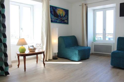 un salon avec deux chaises bleues et une table dans l'établissement Appt Studio LA ROCHELLE - LR180-001, à La Rochelle