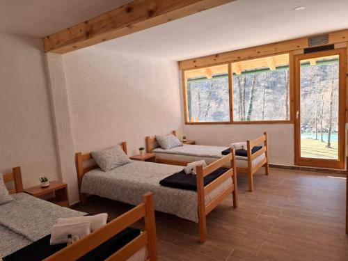 a room with two beds and a window at Rafting kamp HEDERA in Foča