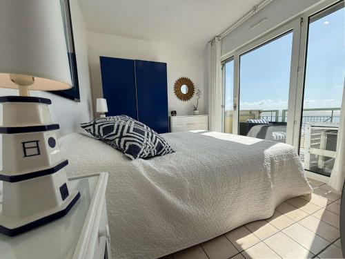 - une chambre avec un lit doté d'une lampe et d'un phare dans l'établissement Appt 2 pièces CHATELAILLON PLAGE - CL040-R24, à Châtelaillon-Plage