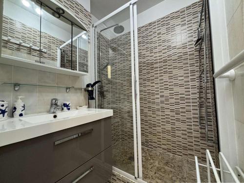 une salle de bain avec une douche en verre et un lavabo dans l'établissement Appt 2 pièces CHATELAILLON PLAGE - CL040-R24, à Châtelaillon-Plage