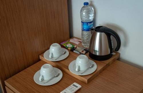 a tea kettle and saucers on a wooden table at Master Family Club in Manavgat