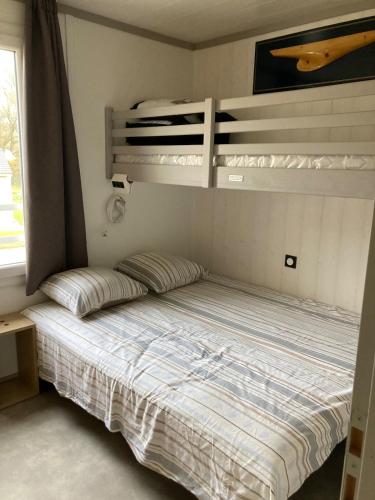 Ce lit se trouve dans un dortoir doté de 2 lits superposés. dans l'établissement Mobil Home piscine chauffée Pont l 'Abbe, à Pont-lʼAbbé