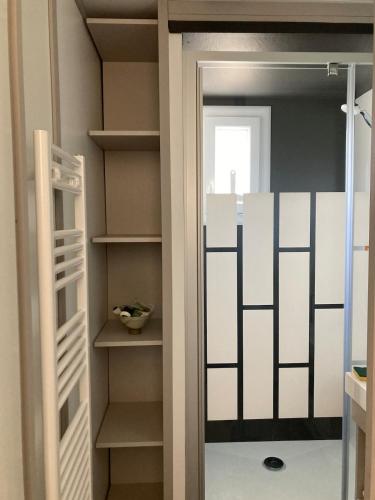 - un dressing avec une porte en verre dans l'établissement Mobil Home piscine chauffée Pont l 'Abbe, à Pont-lʼAbbé