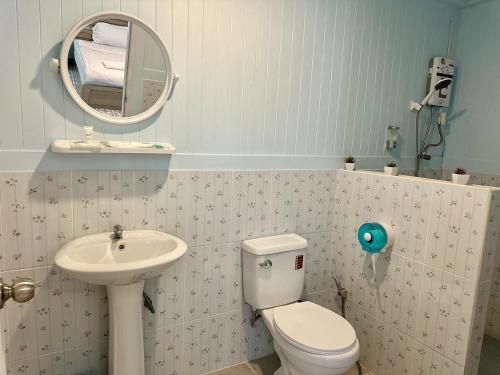 a bathroom with a sink and a toilet and a mirror at Peang Tara Cafe & Resort in Nong Khai