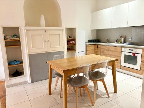 une cuisine avec une table et des chaises en bois dans l'établissement Rossini Flat with Terrace, à Nice