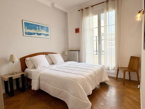 Cette chambre comprend un lit blanc et une grande fenêtre. dans l'établissement Rossini Flat with Terrace, à Nice