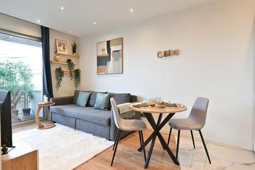 un salon avec un canapé et une table dans l'établissement Charmant appartement Neuilly-sur-seine- II, à Neuilly-sur-Seine