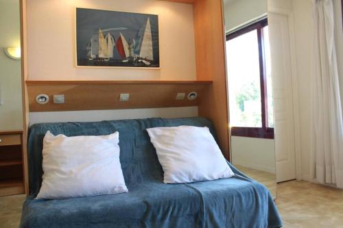 een blauwe bank met 2 kussens in een kamer bij Appt 2 pièces LA ROCHELLE - LR010-022 in La Rochelle