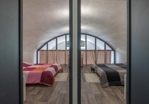 two beds in a room with a window at Le Rempart 15 - Au coeur du Fort in Mercury
