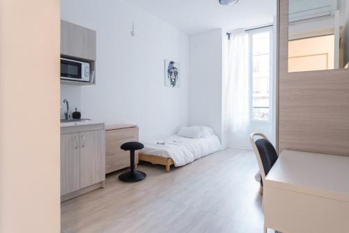 una habitación blanca con una cama y una mesa en Résidence de l'Alliance, en Niza