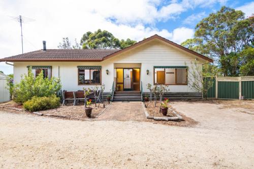 a small white house with a porch at Bells Beach 5BR Retreat in quiet peaceful spaces- with Hot Tub in Bellbrae