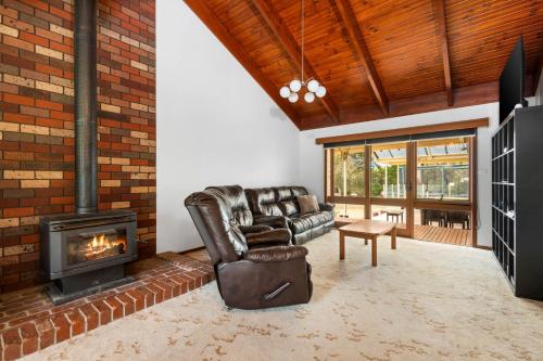 a living room with a couch and a fireplace at Bells Beach 5BR Retreat in quiet peaceful spaces- with Hot Tub in Bellbrae