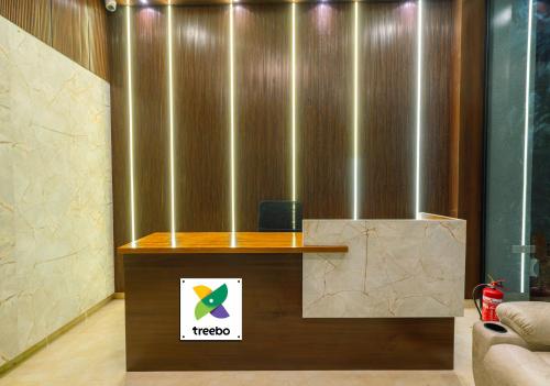 a reception desk in a lobby with a sign on it at Treebo The Living Tree Khairatabad in Hyderabad