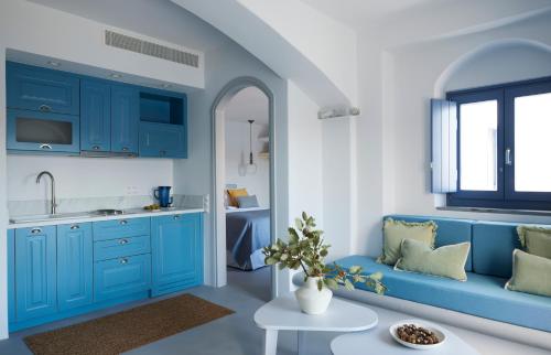 a kitchen with blue cabinets and a blue couch at Kea Mare LV Villas in Gialiskari