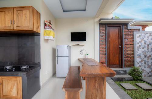 a kitchen with a wooden counter top and a refrigerator at Ubud Mayura Private Pool Villa in Ubud
