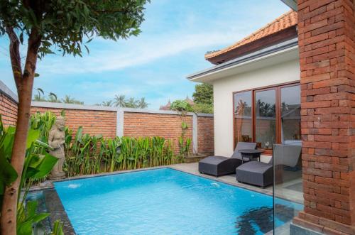 a swimming pool in the backyard of a house at Ubud Mayura Private Pool Villa in Ubud