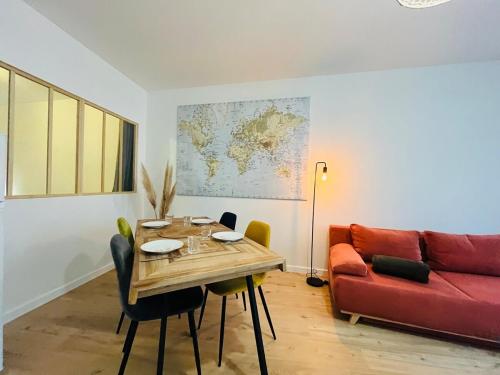 een woonkamer met een tafel en een rode bank bij Casa Diderot - T2 in Angers