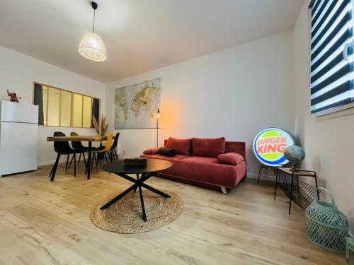 een woonkamer met een rode bank en een tafel bij Casa Diderot - T2 in Angers
