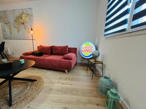 un salon avec un canapé rouge et une table dans l'établissement Casa Diderot - T2, à Angers