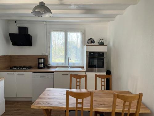 Il comprend une cuisine avec une table et des chaises en bois. dans l'établissement La Bellevue, 15 mn de Toulouse, WIFI, Barbecue, à Labarthe-sur-Lèze