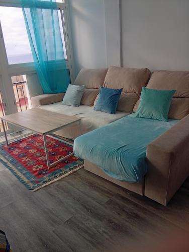 a living room with a couch and a table at Atico primera linea del mar in Sitio de Calahonda