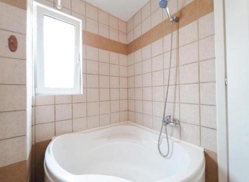 a white tub in a bathroom with a window at Rea Apartment in Argostoli