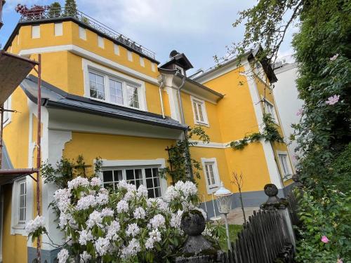 a yellow house with flowers in front of it at Schmiedhäusl in Kitzbühel