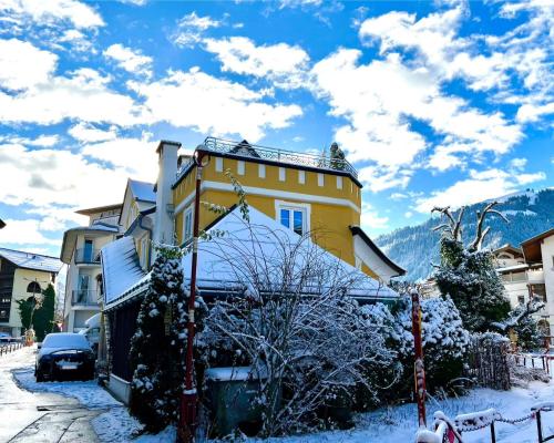 a yellow house with snow on the ground at Schmiedhäusl in Kitzbühel