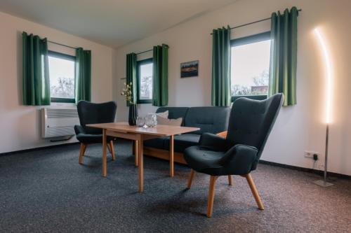 a living room with a table and chairs at Das Schlafgut Dessau Bungalows in Dessau