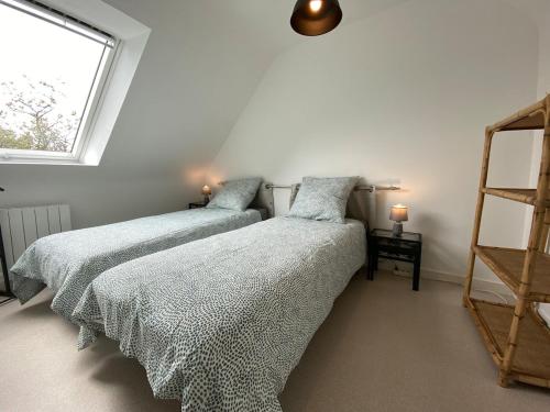 deux lits jumeaux dans une chambre avec fenêtre dans l'établissement maison 5 pers Le Penty d 'Argol Crozon animaux acceptés, à Argol