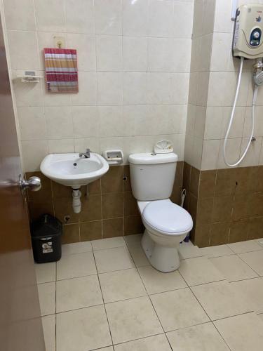 a bathroom with a toilet and a sink at HomeStay Family Fun Shah Alam in Shah Alam