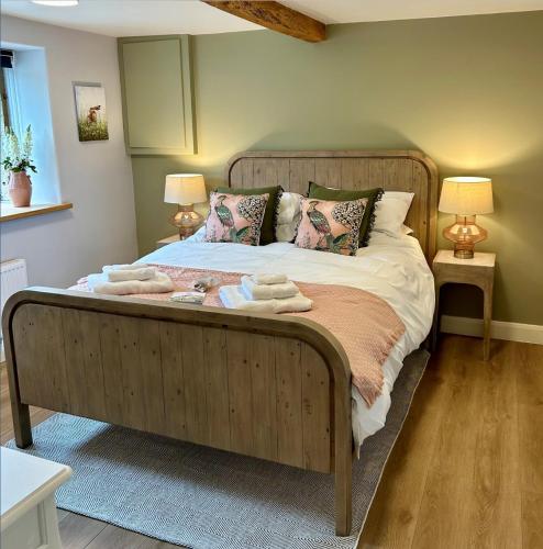 a bedroom with a wooden bed with towels on it at The Pickled Pheasant in Holmfirth