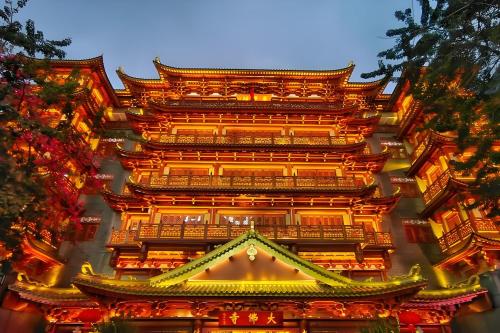 a building with a tower with lights on it at Guangzhou Xi Yun - Lai Xizhou Hotel-Free shuttle bus during Canton Fair in Guangzhou