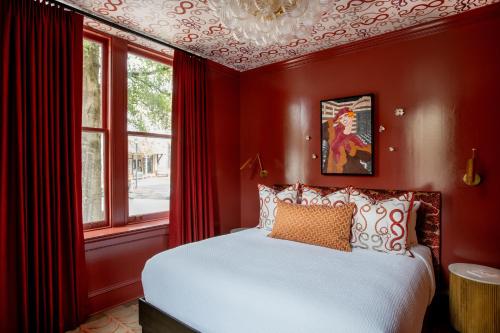 a red bedroom with a bed and a window at The Bell Athens by Kasa in Athens