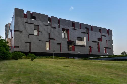 a building with a grass field in front of it at Guangzhou Xi Yun - Lai Xizhou Hotel-Free shuttle bus during Canton Fair in Guangzhou