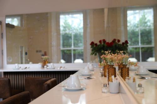 a dining room with a long table with flowers on it at Reem Hotel in London
