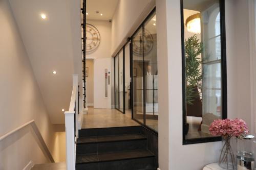 a hallway of a house with black stairs and windows at Reem Hotel in London