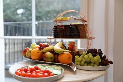 two plates of fruit on a table with a window at Reem Hotel in London