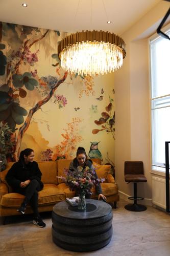 a man and woman sitting on a couch in a living room at Reem Hotel in London