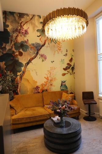 a living room with a couch and a chandelier at Reem Hotel in London
