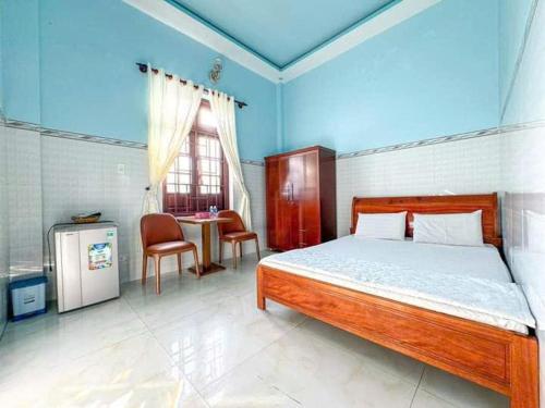 a bedroom with a bed and a table and a window at Thuận Phát in Cu Lao Thu