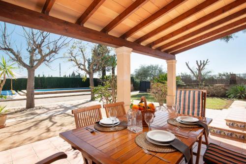 a wooden table under a wooden pergola at Es Ravellar - Campos in Islas Baleares