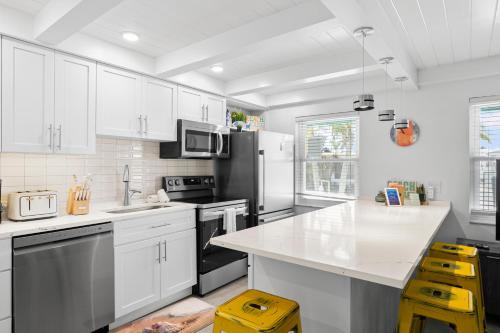 a kitchen with white cabinets and a black refrigerator at Bayview Inn #101 in Bradenton Beach