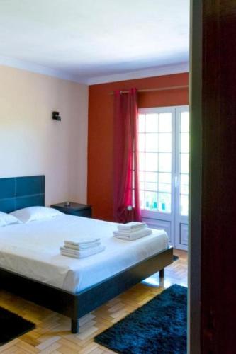 a bedroom with a bed and a large window at Casa de Alvite in Alvito