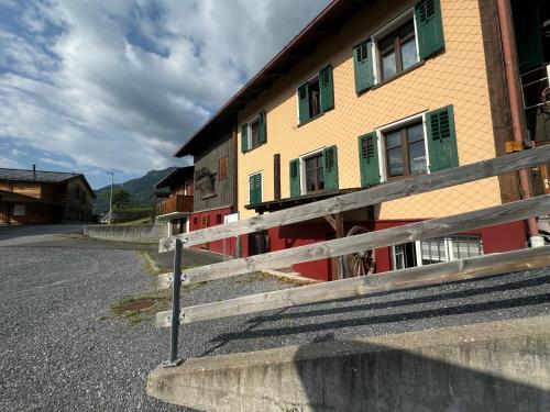 a building with a fence next to a street at AlpenHaus, farmhouse in Triesenberg
